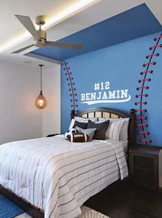 a bedroom decorated in blue and white with a football themed wall decal above the bed