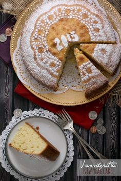 a cake with powdered sugar on top is sitting on a plate next to a knife and fork