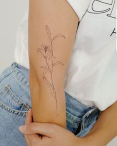 a woman's arm with a flower tattoo on the left side of her arm