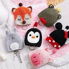 crocheted animal key fobs are laying on a blanket