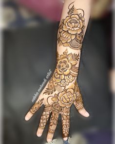 a woman's hand with henna tattoos on it