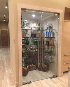 a large glass door in the middle of a room with shelves full of food and drinks