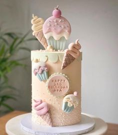 a birthday cake decorated with ice cream and cupcakes