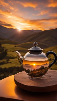 a tea pot with a sunset in the background