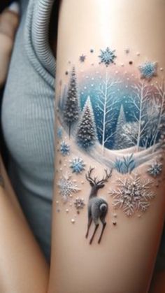 a woman's arm with a deer and snowflakes tattoo on the side