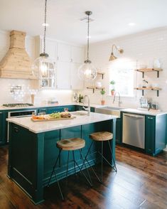 a kitchen with two stools at the island