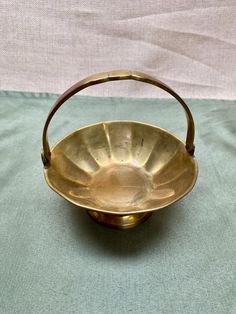 an antique brass bowl on a green cloth