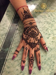 a woman's hand with henna tattoos on it