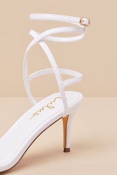 The sexy vibes of the beloved Lulus Sydd Ankle Wrap High Heel Sandals just got a comfy upgradeâ€”the Lulus Sydd White Ankle Wrap Low Heel Sandals! Smooth faux leather shapes these must-have heels that feature a single sole silhouette with an almond-shaped footbed and a slender toe strap. Matching straps sprout from the sides to wrap and secure around the ankle with a gold buckle, all atop a low, stiletto-style heel! 2. 75" Stiletto heel. Lightly cushioned insole. Rubber sole has nonskid markings Chic Adjustable Wedding Sandals, Chic Adjustable High Heel Sandals, Chic Adjustable Strappy Heels, Feminine Ankle Strap Sandals For Night Out, Elegant Ankle Wrap Sandals For Summer, Feminine Strappy Sandals For Party, Chic Ankle Wrap Sandals With Heel Loop, Feminine Open Heel Sandals For Night Out, Feminine Strappy Heels