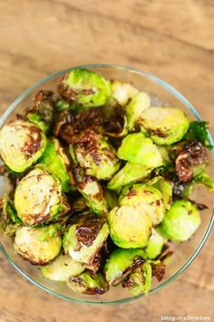 a wooden bowl filled with brussel sprouts on top of a table