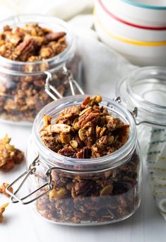 three glass jars filled with granola and nuts