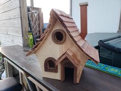 a bird house made out of wood sitting on top of a table