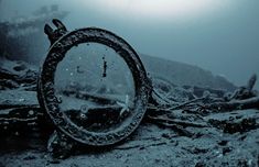 an old ship wreck in the ocean with water around it and debris on the ground