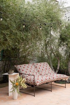 a couch sitting on top of a patio next to a tree