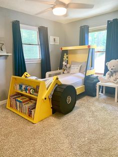 a child's bedroom decorated in blue, yellow and white with a tractor bed