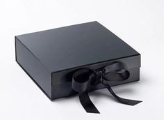 a black box with a ribbon tied around the top and bottom, on a white background