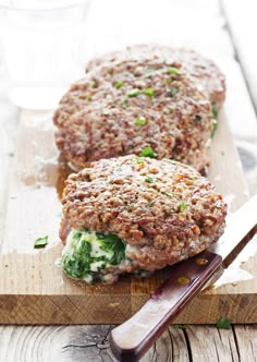 two hamburger patties sitting on top of a cutting board