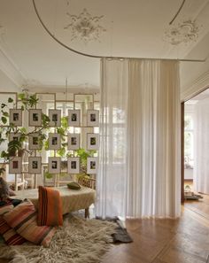 a living room filled with lots of furniture and pictures on the wall next to a window