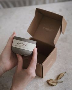 a person holding an embre soap in front of a box with the word embre on it