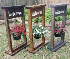 three wooden planters with flowers in them on the grass