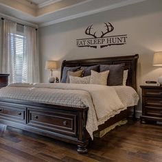 a large bed sitting in a bedroom on top of a hard wood floor next to two lamps