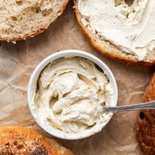 an assortment of bagels with cream cheese in the middle and one on the side