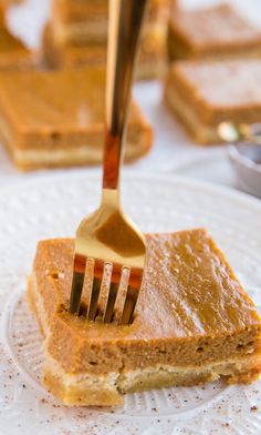 a fork is stuck into a piece of cake on a plate with other desserts in the background