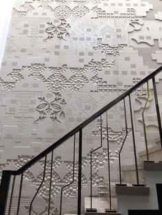 a stair case with decorative paper on the wall and handrails next to it