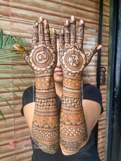 a woman is holding her hands up with hendi designs on it's palms