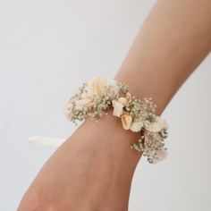 a close up of a person's hand wearing a bracelet with flowers on it