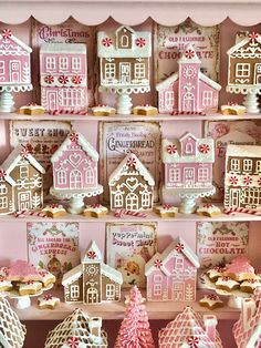 gingerbread houses and cookies are on display in a pink room with white trimmings