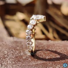 a diamond ring sitting on top of a stone slab in front of a wooden background