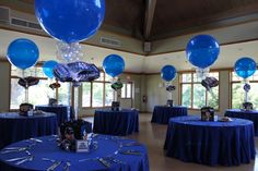 balloons and table cloths are set up in the middle of a room with blue tables