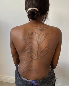 the back of a woman's body with tattoos on her upper and lower back