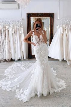 a woman is taking a selfie in front of her wedding gowns and dresses