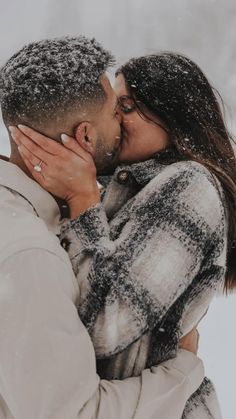 a man and woman kissing in the snow