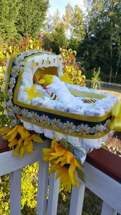 a baby's crib with sunflowers on the bottom and yellow flowers around it