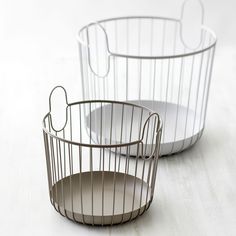 two wire baskets sitting next to each other on a table