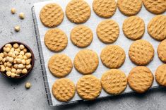 peanut butter cookies are arranged on a baking sheet next to a bowl of chickpeas