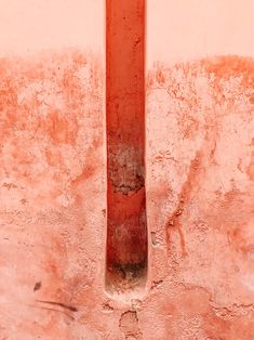 a red fire hydrant sitting on the side of a building next to a wall