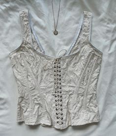 "Rare Vintage Gigi Clark ivory floral corset top, lace up. Cotton. Hook and eye closure. size S, pit to pit 34\", waist 26\", length 20.5\". very good vintage condition, slight discoloration due to age. not very noticeable" White Fitted Corset With Lace-up Back, Spring Fitted Corset With Hook And Eye Closure, Beige Lace Fitted Corset, Cream Lace Corset With Boned Bodice, Spring Lace Trim Fitted Corset, Spring Fitted Corset With Lace Trim, Beige Spring Corset With Corset Back, Beige Corset With Corset Back For Spring, White Lace-up Corset For Spring