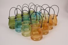 many different colored vases are lined up on a white surface with black string around them