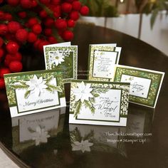 four cards with white flowers on them sitting on a table