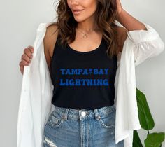 "This cute Retro tampa bay lightning tank top would make a great gift for that special lightning fan! Cute retro tb lightning tank, retro lightning tank, retro flower tank, tampa tank top, lightning tank top, retro tampa bay, groovy tampa tank --------HOW TO ORDER-----------  1)Select SHIRT OR SWEATSHIRT (Size / Style) and COLOR  2)Select your desired Size  3)Double check the size chart to find your fit  4)Click \"Add to Cart\" and continue shopping to add another shirt for your loved ones. Sizi Tampa Bay Lightning, Retro Flowers, Text Design, Fit Style, Color 2, Size Charts, Tampa Bay, Womens Tank, Womens Clothing Tops