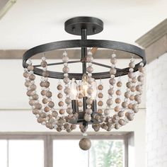 a chandelier with beads hanging from it's metal frame and wood accents