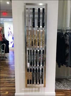 a display case with several pairs of necklaces hanging from it's sides in a clothing store