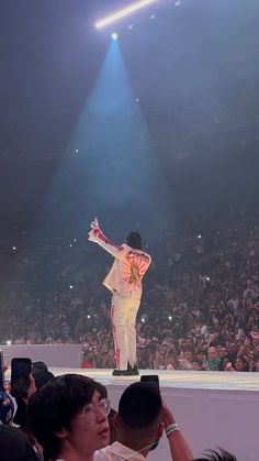 a man standing on top of a stage in front of a crowd