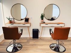 two salon chairs with mirrors on the wall