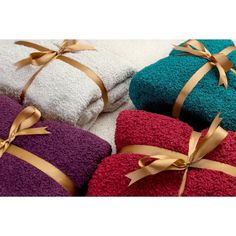 towels wrapped in different colors and tied with gold ribbon