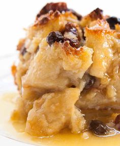 a piece of bread pudding with raisins and caramel sauce on a plate